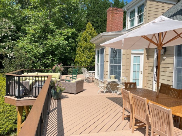 deck on the back of a home with patio furniture